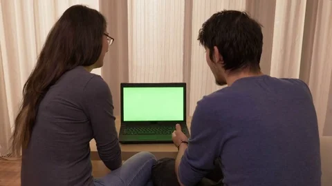 Young students sitting on the couch at home discussing and comparing prices o Stock Footage 83046141