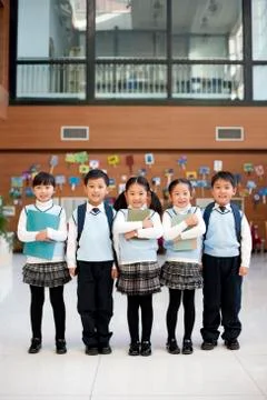 Young students standing in a row at school Stock Photos