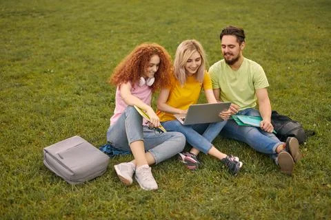 Young students using laptop in park Stock Photos