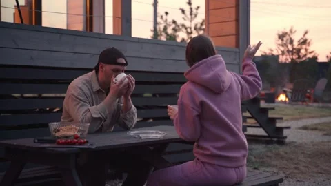 Young stylish couple is chatting while sitting at a table in their beautiful Stockbeeldmateriaal 245992488