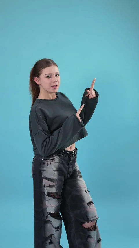 Young Stylish Female Posing and Gesturing on Blue Studio Background Stock Footage 344777538