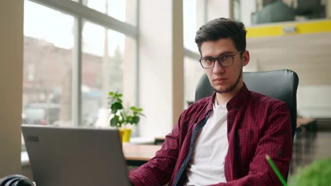 Young stylish freelancer working with laptop then looking at camera. Office Stock Footage 220251014
