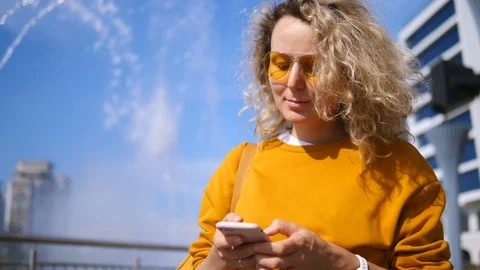 Young Stylish Girl Using Cell Phone In City Outdoors. Video stock 118733092