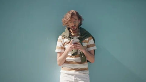 Young stylish guy isolated at blue background. Elegant bearded male holding Stock Footage 278909234