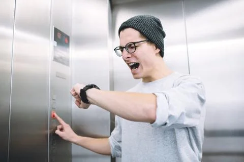 Young stylish guy standing in elevator Stock Photos