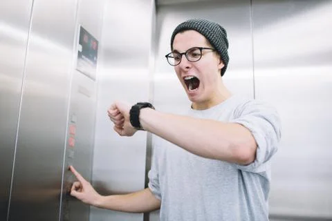 Young stylish guy standing in elevator Stock Photos
