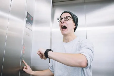 Young stylish guy standing in elevator Stock Photos