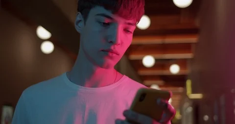 Young Stylish Guy Wearing White T-Shirt Using his Smartphone Looking at Screen Stockbeeldmateriaal 119360604