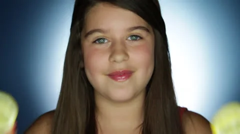 A young stylish kid keeps lemon in her hand to eye with the pretty actions Stock Footage 22929897