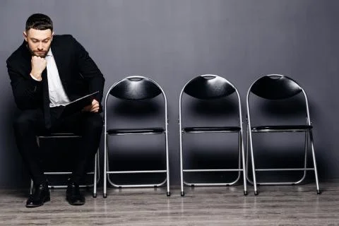 Young stylish man with beard is preparing for the interview. He is in a suit, Stock Photos