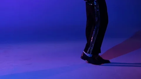 Young stylish man dancing in style Michael Jackson, spotlight on a blue Stock Footage 122085169