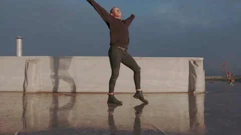 Young stylish man dancing on the wet brilliant floor after the rain outdoor and Stock Footage 105463713