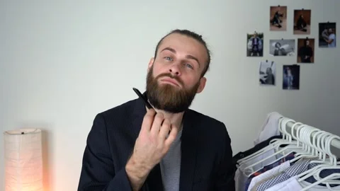 Young Stylish man in a suit  is looking in a mirror is combing his beard Stock Footage 147900146