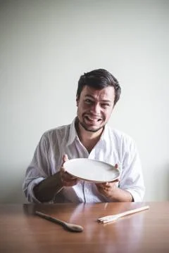 Young stylish man with white shirt eating in mealtimes Stock Photos