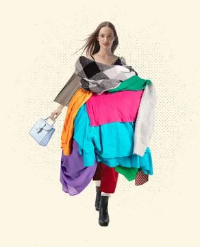 Young stylish woman in a pile of different clothes isolated on white background Stock Photos