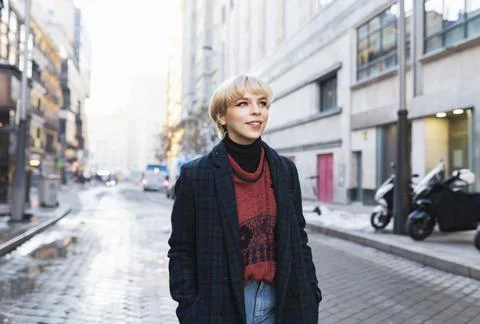 Young stylish woman standing on winter city street Stock Photos
