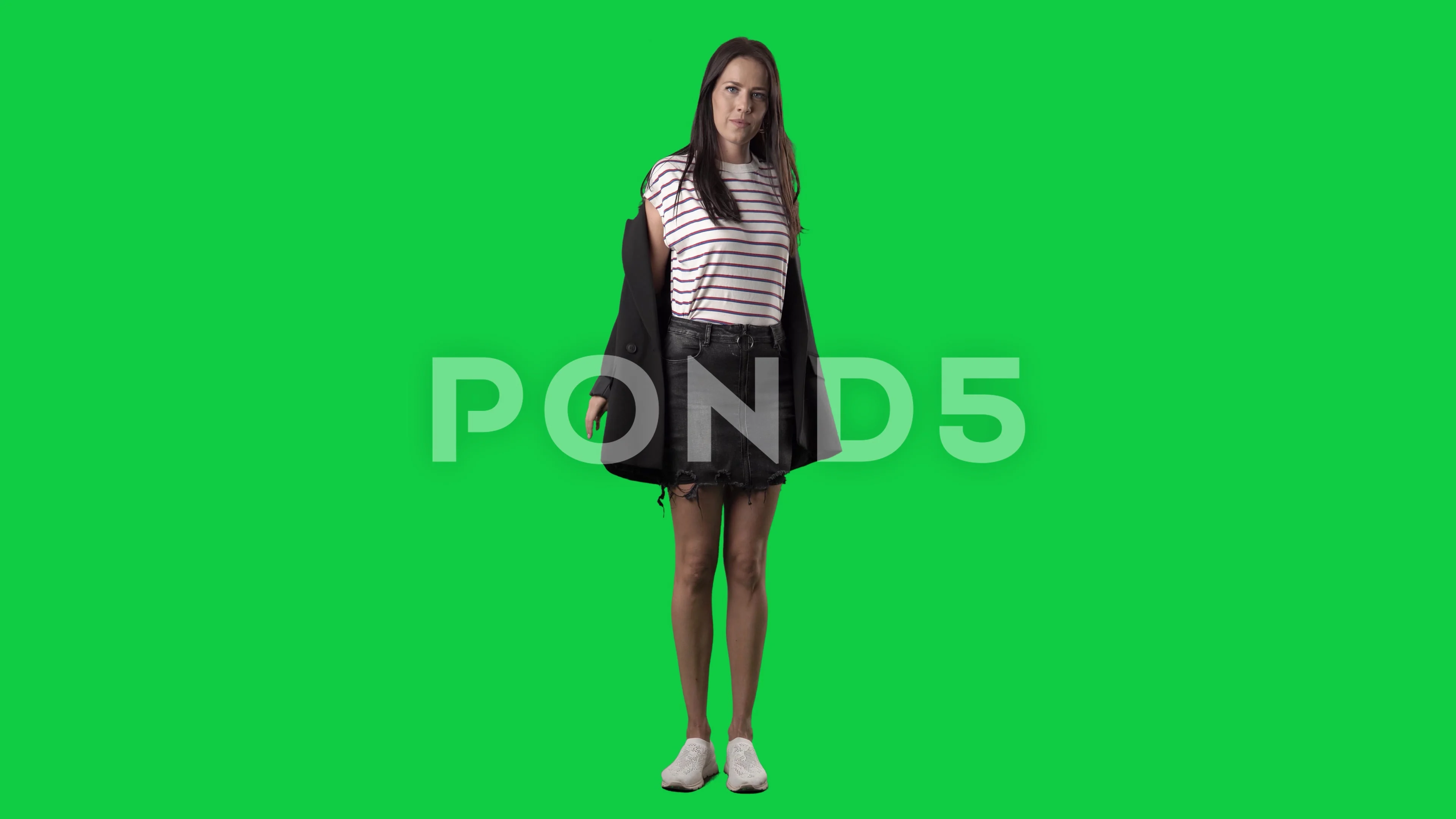 Young stylish woman undressing removing suit jacket. Full body on green  screen