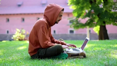 Young successful freelancer man using modern laptop sitting in sunny green park 스톡 동영상 139616610