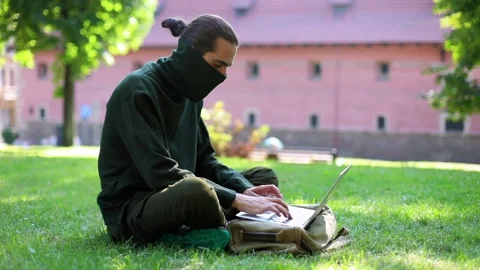 Young successful freelancer with protected face using laptop computer while Video stock 139750459