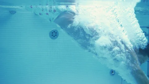 Young successful guy dives under the water of the pool in slow motion Stock Footage 102652307