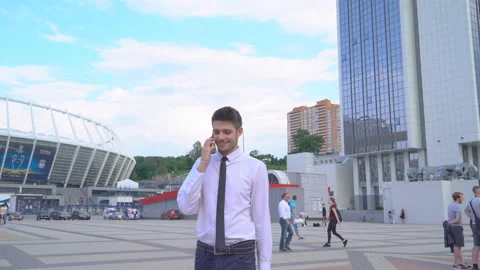 Young successful guy student working on the street on laptop. A man in a white Stock Footage 91418684