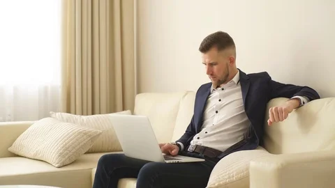 Young successful handsome man working with computer in a hotel room Stock Footage 73899522