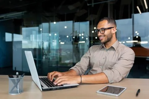 Young successful Indian programmer working inside modern development company Stock Photos