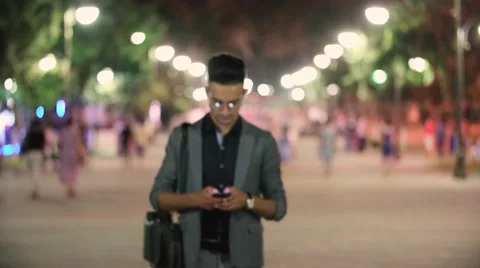 Young successful Manager, walk through the city at night after work, texting on Stock Footage