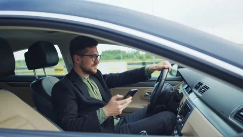 Young successful start-up developer businessman driving car and using mobile Stock Footage 135132777