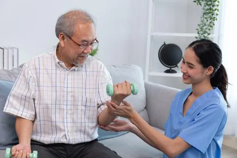 A young support helping a senior man working out. Stock Photos