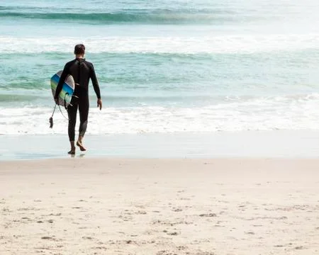 Young surfer on the beach Stock Photos