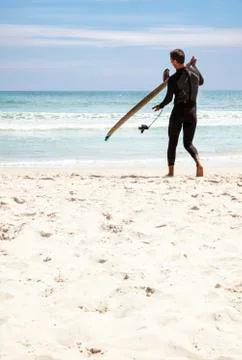 Young surfer on the beach Stock Photos