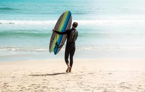 Young surfer on the beach Stock Photos