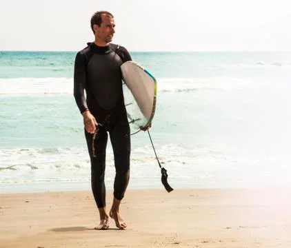 Young surfer on the beach Stock Photos
