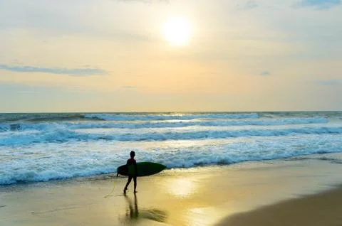 Young surfer on the beach Stock Photos