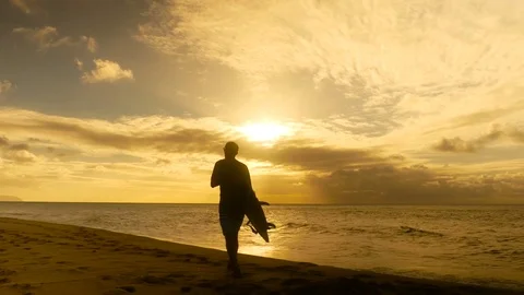Young surfer on the beach waiting for perfect waves at sunset Stock Footage 71837501