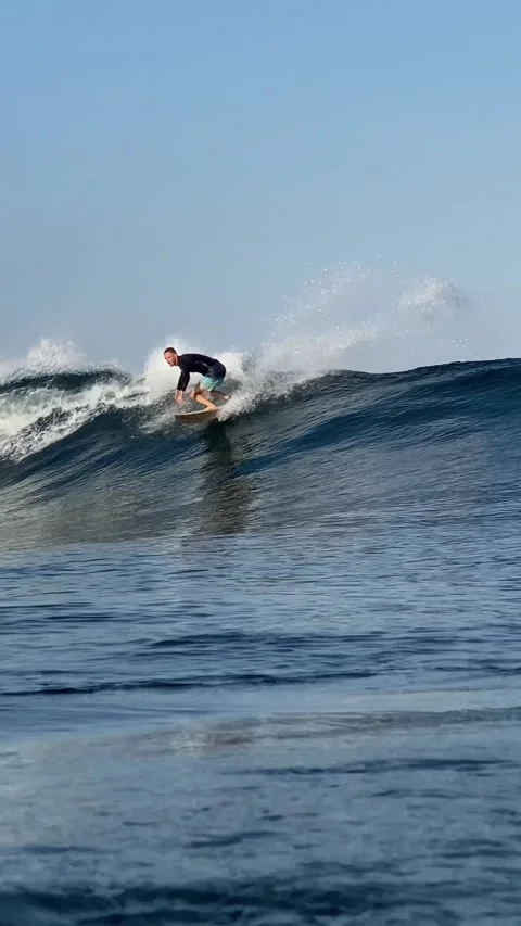 Young surfer on a blue wave. Vertical video Stock Footage 300748219
