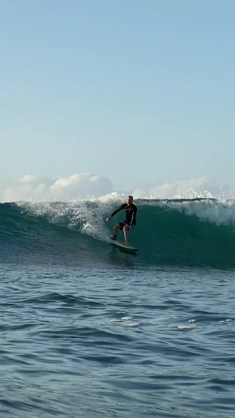 Young surfer on a blue wave. Vertical video Stock Footage 300748220