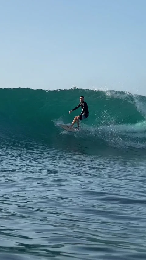 Young surfer on a blue wave. Vertical video Stock Footage 300748234