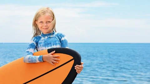 Young surfer learn to ride on surfboard on sea waves Stock Photos