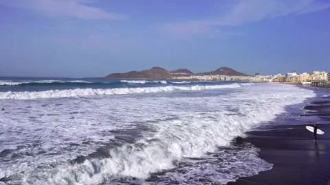 Young surfer is looking at the waves on the beach. Stock Footage 152884037