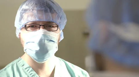 Young Surgeon Looks Up From Operating Table Stock Footage 50941286
