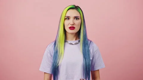Young surprised lady with colorful hairstyle looking around and shaking head in Stock Footage 188773104