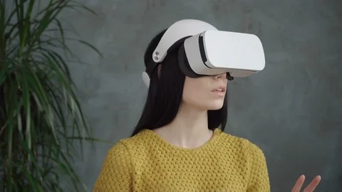 Young surprized woman using virtual reality headset at home Stock Footage 74954939