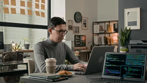 Young System Administrator Working on Laptop at Wooden Desk in Modern Office Stock Footage 329613457