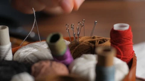 Young tailor attaches white textile pieces with sewing pins making reusable f Stock Footage 128363659