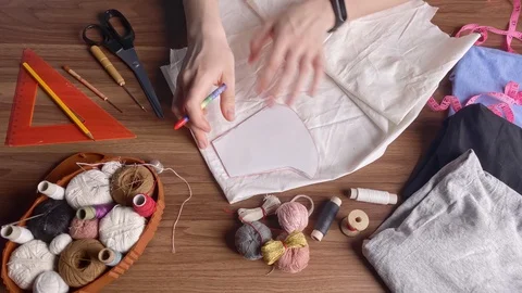 Young tailor uses red pencil to transfer patterns reusable protective mask on Video stock 128362994