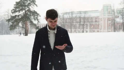 Young tall man walking during snowstorm Stock Footage 72737358