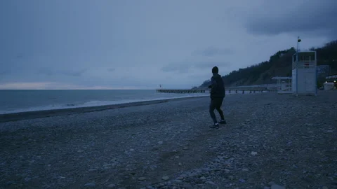 Young tall person is doing warm up. Training on open air at nasty weather Stock Footage 147922907