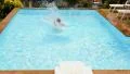 Young Tanned Man Jumping into Swimming Pool. Slow Motion. HD Footage
